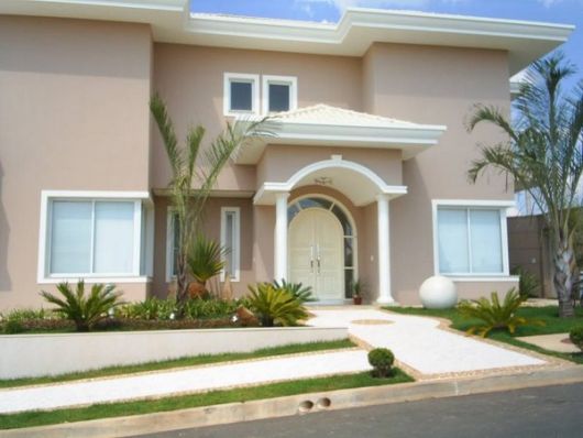Fachada residencial com molduras e pórtico de entrada