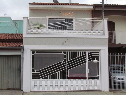 Fachada com portão emoldurado em concreto